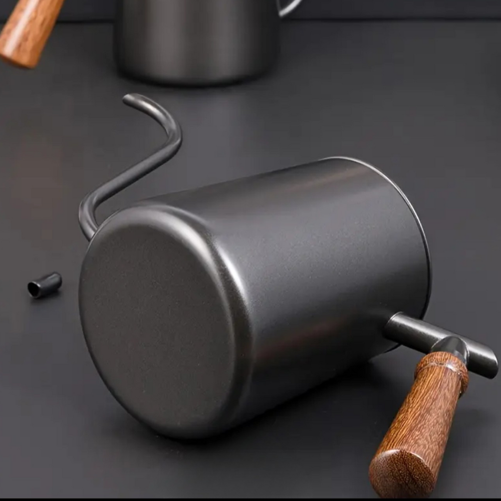 Metal coffee scoop with wooden handle on a dark surface