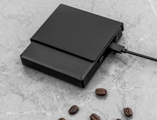 0.1g High Precision Drip Espresso Scale being charged with Type-C cable connected on the side, showing fast and convenient charging.

