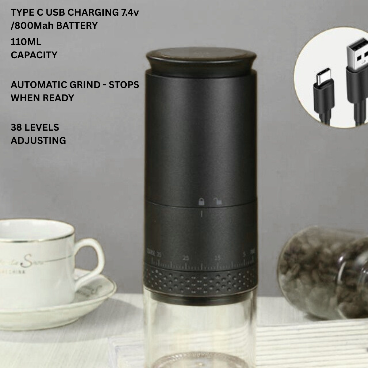 Black portable coffee grinder with USB charging cable on a gray background