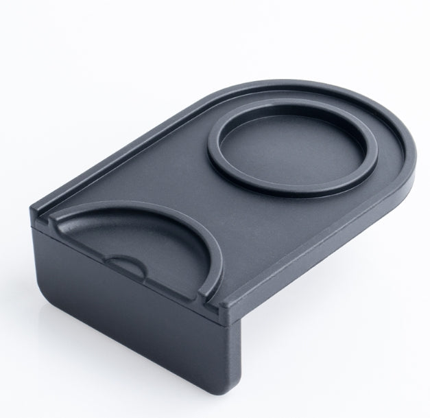 Black silicone mat with circular indentations on a white background
