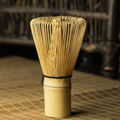 Bamboo whisk used for making matcha tea on a woven mat