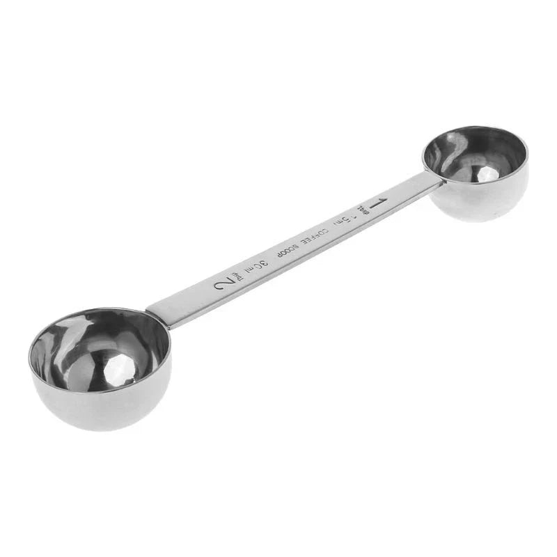 Two stainless steel measuring spoons on a white background