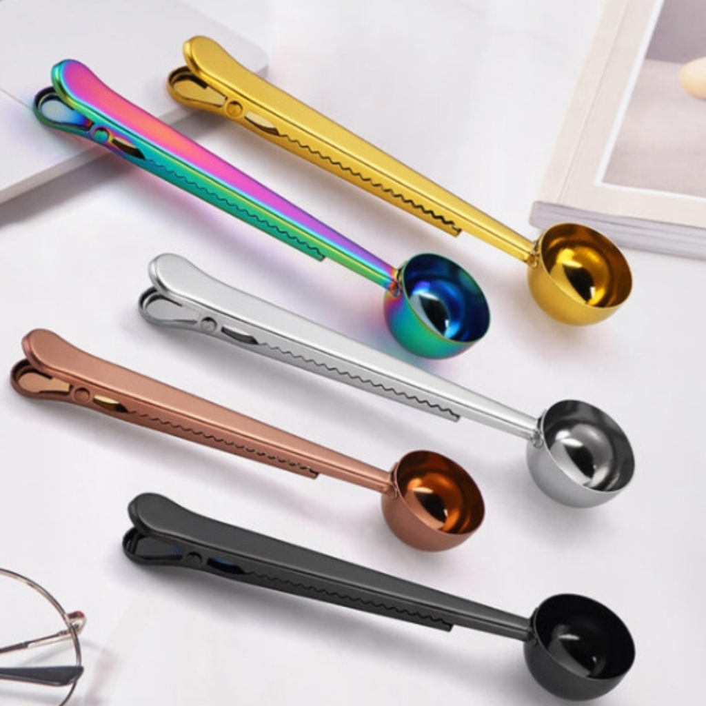 Set of colorful metal measuring spoons on a white surface